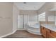 Bright bathroom featuring a soaking tub, walk-in shower, and wood-look flooring at 13304 W Palo Verde Dr, Litchfield Park, AZ 85340