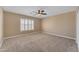 Neutral bedroom featuring carpet, light walls, fan, and shuttered window for serene living at 13304 W Palo Verde Dr, Litchfield Park, AZ 85340