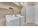 Bright laundry room featuring a washer, dryer, neutral paint, tile floors, and ample storage shelves at 13304 W Palo Verde Dr, Litchfield Park, AZ 85340
