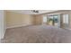 Large living room with carpet, ceiling fan and glass sliding doors to an exterior patio at 13304 W Palo Verde Dr, Litchfield Park, AZ 85340