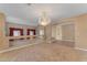 Living room features a chandelier, neutral carpet, and an open floor plan for easy entertaining at 13304 W Palo Verde Dr, Litchfield Park, AZ 85340