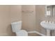 Powder room featuring a toilet and a white pedestal sink at 13304 W Palo Verde Dr, Litchfield Park, AZ 85340