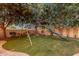 Spacious backyard with swing set, slide, and mature trees, creating a fun and inviting outdoor play area at 1356 E Flamingo Ct, Gilbert, AZ 85297