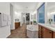 Bright bathroom featuring a soaking tub, dual vanities, and a spacious walk-in closet at 1356 E Flamingo Ct, Gilbert, AZ 85297