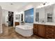 Beautiful bathroom featuring a large tub, dual vanities, walk-in closet, warm lighting, and large mirror at 1356 E Flamingo Ct, Gilbert, AZ 85297