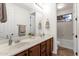Bathroom with double sink vanity, framed mirrors, and a tiled shower at 1356 E Flamingo Ct, Gilbert, AZ 85297