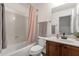 Cozy bathroom featuring a shower-tub combo, tile flooring, and a wood vanity with sink and a pleated pink shower curtain at 1356 E Flamingo Ct, Gilbert, AZ 85297
