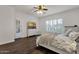 Comfortable bedroom with hardwood floors, a ceiling fan, shuttered windows, dresser with TV, and a cozy bed at 1356 E Flamingo Ct, Gilbert, AZ 85297