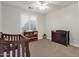 Cozy Bedroom with carpet, ceiling fan, window with blinds, and a dark wooden crib at 1356 E Flamingo Ct, Gilbert, AZ 85297