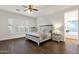 Bright bedroom with wood floors, ceiling fan, shuttered windows, and a lovely bed, dresser, and nightstand at 1356 E Flamingo Ct, Gilbert, AZ 85297
