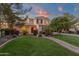 Inviting two-story home featuring lush landscaping, a brick walkway, and a welcoming front porch at 1356 E Flamingo Ct, Gilbert, AZ 85297