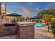 Outdoor kitchen featuring a built-in grill and counter space overlooking the pool area at 1356 E Flamingo Ct, Gilbert, AZ 85297