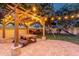 Outdoor pergola with dining area and string lights, creating a cozy and inviting space for entertaining in the backyard at 1356 E Flamingo Ct, Gilbert, AZ 85297