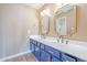 Bathroom features double sinks, large mirrors, and navy blue cabinets with gold hardware at 14234 N 26Th Ln, Phoenix, AZ 85023