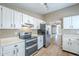 Well-equipped kitchen with sleek stainless steel appliances, white cabinets, and laminate flooring at 14234 N 26Th Ln, Phoenix, AZ 85023
