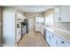 Bright, modern kitchen with white cabinets, laminate floors, and stainless steel appliances at 14234 N 26Th Ln, Phoenix, AZ 85023