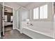 Bathroom with tub, shower, plantation shutters, and view of the bedroom at 15731 W Redfield Rd, Surprise, AZ 85379