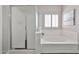 All-white bathroom features a soaking tub with shower and plantation shutters at 15731 W Redfield Rd, Surprise, AZ 85379