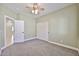 Bedroom with green walls, neutral carpet, closet, ceiling fan and doors to adjoining rooms at 15731 W Redfield Rd, Surprise, AZ 85379