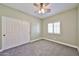 Bedroom with green walls, neutral carpet, closet with white doors, ceiling fan and window at 15731 W Redfield Rd, Surprise, AZ 85379