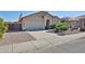 Charming single-story home featuring a two-car garage, desert landscaping, and an American flag at 15731 W Redfield Rd, Surprise, AZ 85379