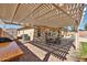 Relaxing patio with a pergola, brick pavers, a dining table, and partial view of the pool at 15731 W Redfield Rd, Surprise, AZ 85379