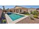 Beautiful backyard featuring a private pool, covered patio, and low-maintenance desert landscaping at 15731 W Redfield Rd, Surprise, AZ 85379