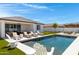 Beautiful backyard showcases a modern pool, sun loungers, and a covered patio, creating an ideal outdoor living space at 17084 N Palo Pino St, Maricopa, AZ 85138