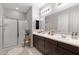 This bathroom features a double sink vanity and glass enclosed walk in shower at 17084 N Palo Pino St, Maricopa, AZ 85138