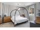 Bright bedroom featuring a modern canopy bed, side tables with lamps, and a large window for ample light at 17084 N Palo Pino St, Maricopa, AZ 85138