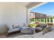 Stylish covered patio with plush seating overlooks the sparkling pool and manicured yard, perfect for outdoor entertaining at 17084 N Palo Pino St, Maricopa, AZ 85138