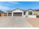 Charming single-story home featuring a three-car garage and desert landscaping at 17084 N Palo Pino St, Maricopa, AZ 85138