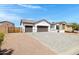 Single-story home featuring a three-car garage, desert landscaping, and a paved driveway at 17084 N Palo Pino St, Maricopa, AZ 85138