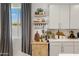 A kitchen showcasing floating shelves, modern white cabinets, and a window letting in natural light at 17084 N Palo Pino St, Maricopa, AZ 85138