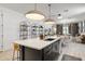 Kitchen island with sink and seating, pendant lighting, and an open floor plan to the dining and living areas at 17084 N Palo Pino St, Maricopa, AZ 85138