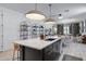 Open-concept kitchen with a large island, modern lighting, and seamless flow to the living area at 17084 N Palo Pino St, Maricopa, AZ 85138