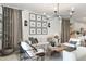 Living room with a modern chandelier, white furniture, wooden floors, and decorative wall art at 17084 N Palo Pino St, Maricopa, AZ 85138