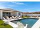 Backyard oasis featuring a modern pool, lounge chairs, and lush artificial turf at 17084 N Palo Pino St, Maricopa, AZ 85138