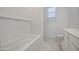 Bright bathroom features a tub with white subway tile surround, and white vanity with solid surface countertop at 17803 W Elm St, Goodyear, AZ 85395