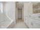 Bright bathroom featuring double sink vanity, soaking tub, and neutral tile at 17803 W Elm St, Goodyear, AZ 85395