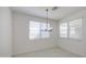 Dining room with modern chandelier lighting and neutral tile flooring at 17803 W Elm St, Goodyear, AZ 85395