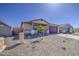 Single-story home with desert landscaping, brown stucco, brick driveway, and stone pillar accents at 17803 W Elm St, Goodyear, AZ 85395