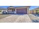 Close up of a single-story home with a brick driveway, large garage door, and desert landscaping at 17803 W Elm St, Goodyear, AZ 85395