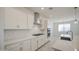 Close up of kitchen features stainless vent hood and gas cooktop with white cabinets at 17803 W Elm St, Goodyear, AZ 85395