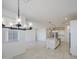 Bright, open-concept living and dining area featuring modern lighting and tile flooring at 17803 W Elm St, Goodyear, AZ 85395