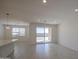 Open living area with tile floors, recessed lighting, and a sliding glass door to a patio at 17803 W Elm St, Goodyear, AZ 85395