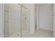 Modern bathroom shower featuring glass doors and built in shelving at 17803 W Elm St, Goodyear, AZ 85395