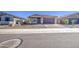 A single-story home with desert landscaping, neutral colors, and a brick driveway in a community at 17803 W Elm St, Goodyear, AZ 85395