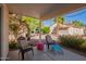 Charming covered patio area with comfortable seating surrounded by lush plants and landscaping at 1803 E Palm Beach Dr, Chandler, AZ 85249