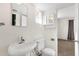 Powder room featuring a pedestal sink and commode with a view into the bedroom at 1944 W Osborn Rd, Phoenix, AZ 85015